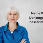 Focusing Coach Birgit Krüger mit weißem Haar und Pony, trägt ein blaues Hemd und blickt ruhig in die Kamera. Neutraler Hintergrund mit schwarzem Text: "Meine Vision: Denkergebnisse besser machen mit Focusing"