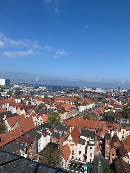 „Blick über die Dächer von Wismar bis zur Ostsee – rote Ziegeldächer, Werftkräne und Weite. Foto gemacht von Focusing-Coach Birgit Krüger auf ihrer Reise an die Ostsee